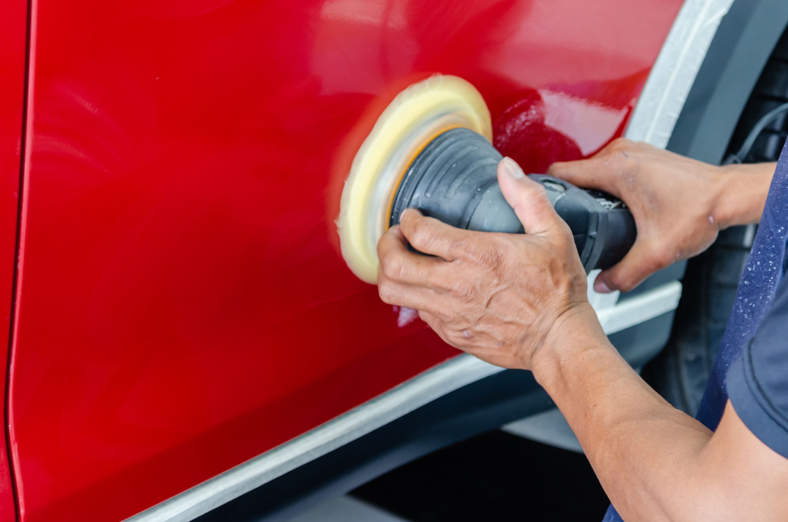 Polishing a freshly painted red panel