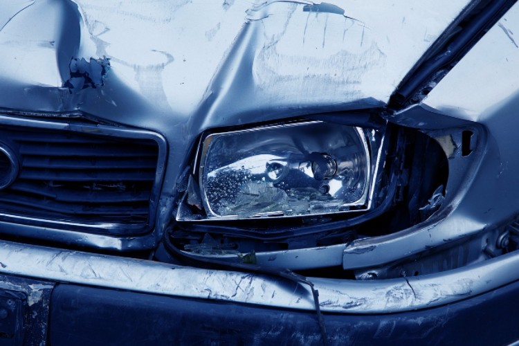 A crushed front end and broken headlight waiting for repair