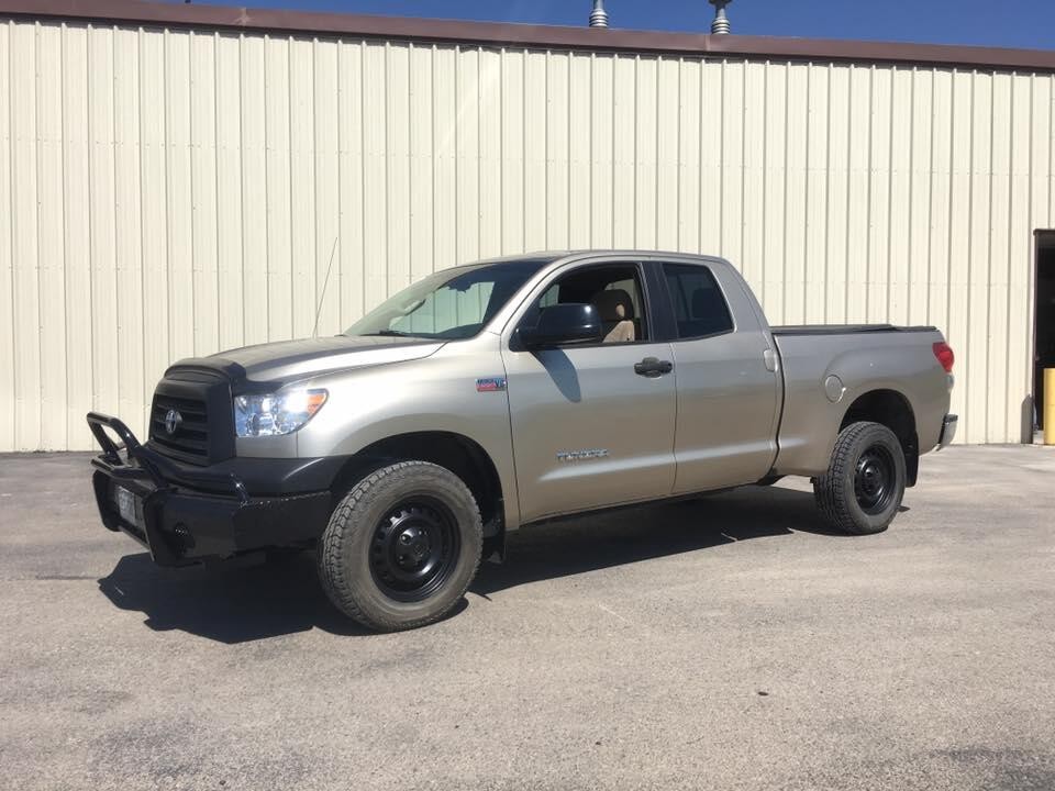The same Toyota Tundra after repair, parked in front of the Doug's Auto Body shop